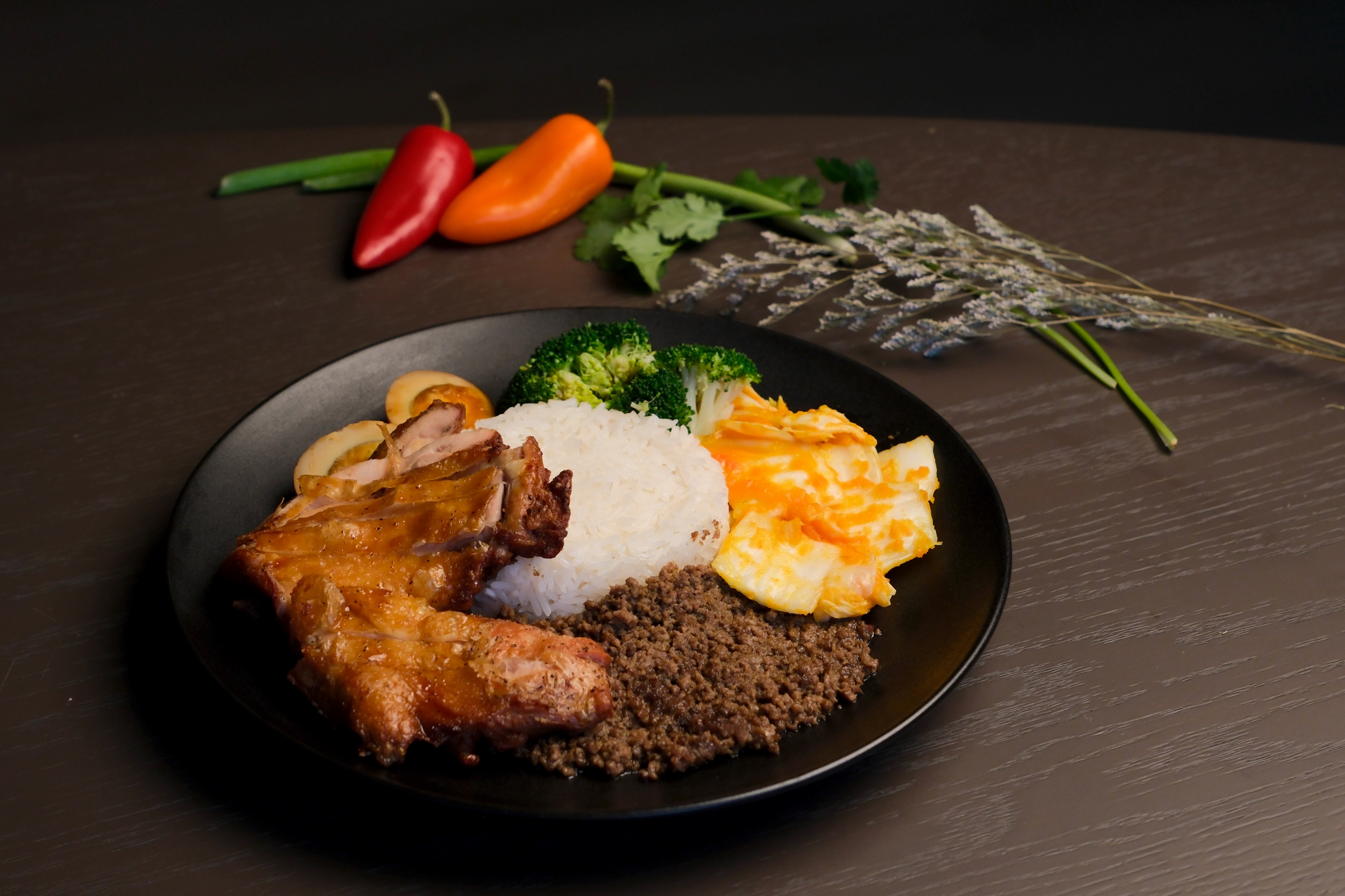 A rice plate with chicken, egg, and vegetables